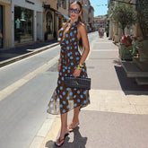 A woman modeling a polka dot suspender skirt suit with a V-neck tank.